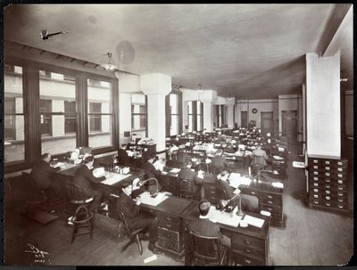 Men and one woman working at desks in an office at the Metropolitan Life Insurance Co. at 23rd Street and Madison Avenue, New York by Byron Company
